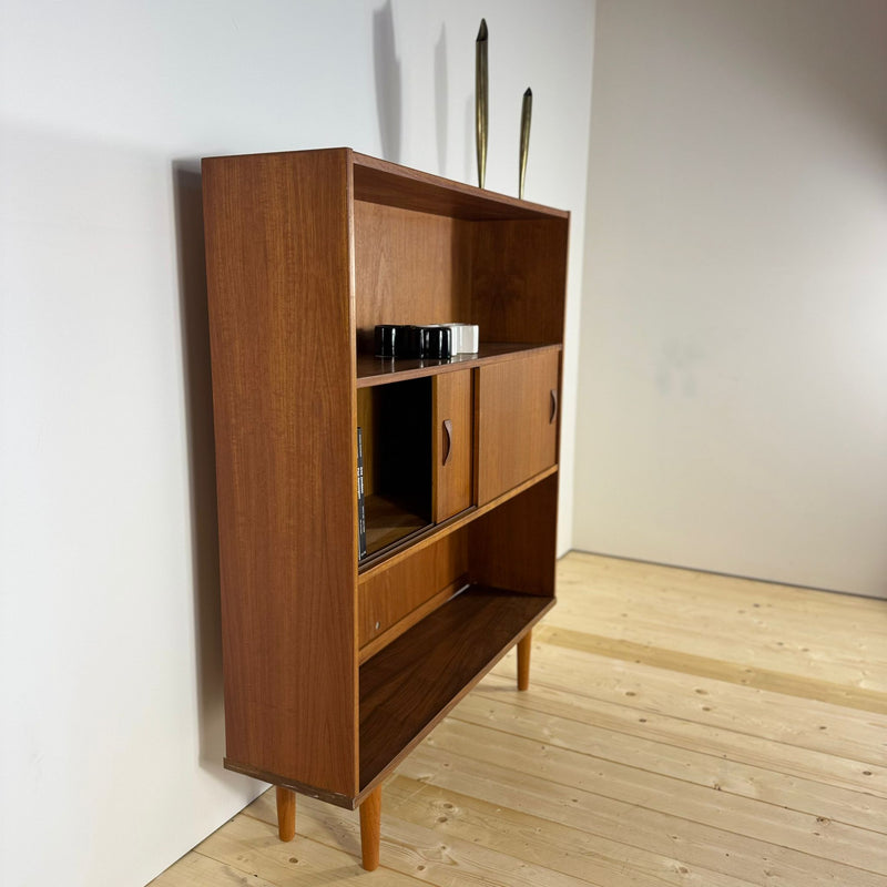 Mensole regolabili in legno di teak con libri o oggetti decorativi.