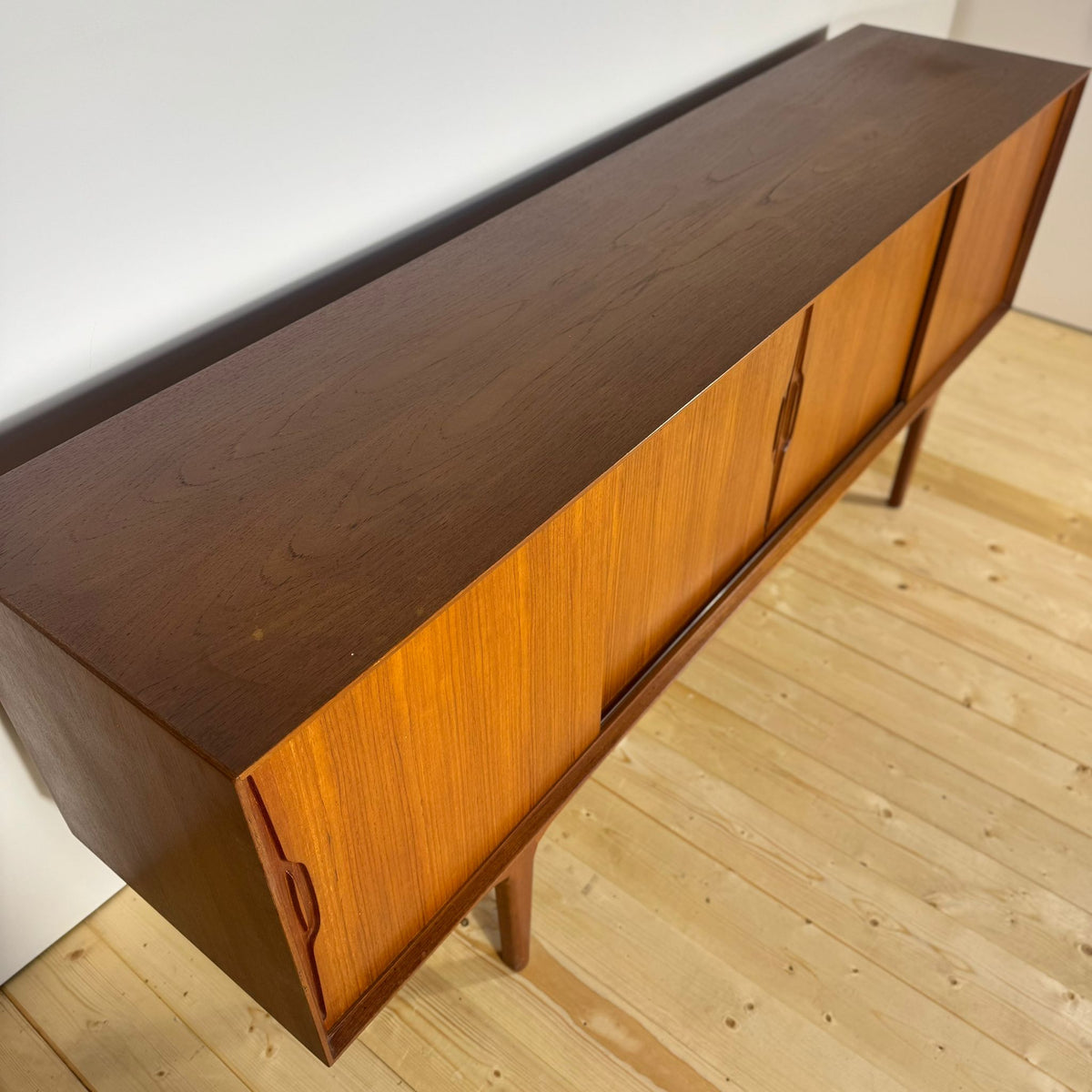 Sideboard in teak ambientato in salotto moderno con piante.