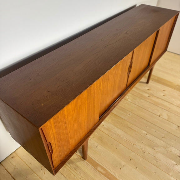 Sideboard in teak ambientato in salotto moderno con piante.